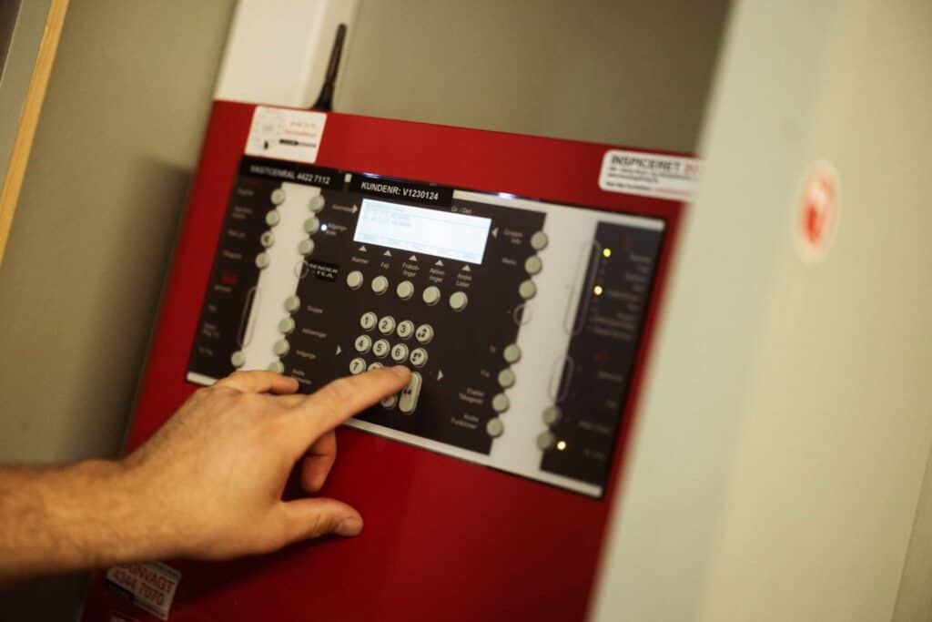Elektriker betjener avanceret brandalarm for at sikre korrekt installation