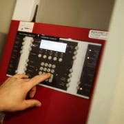Elektriker betjener avanceret brandalarm for at sikre korrekt installation