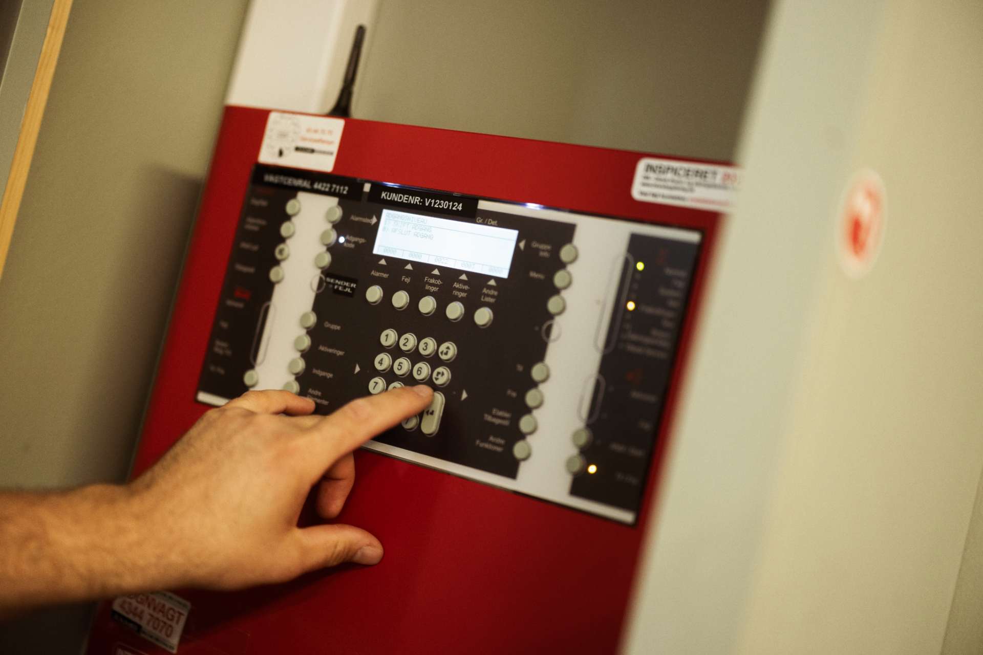 Elektriker betjener avanceret brandalarm for at sikre korrekt installation